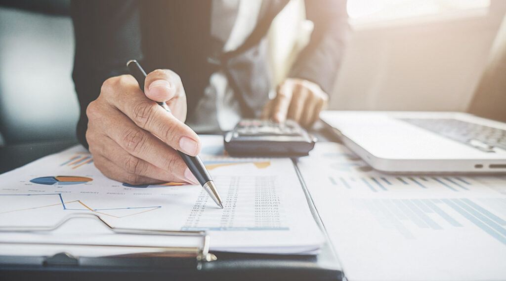 Main avec stylo sur une feuille de statistique