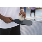 Set de pickleball avec 2 raquettes et 1 balle dans sac en filet couleur bleu marine vue d'ambiance