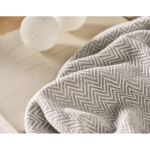 Plaid à franges en coton recyclé présenté avec un ruban 400 g/m² couleur beige vue d'ambiance