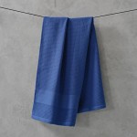 Serviette de douche 50x100cm en coton recyclé gaufré 500g/m² couleur bleu marine vue d'ambiance